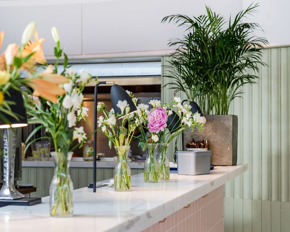 Cocina decorada con muchos jarrones con flores