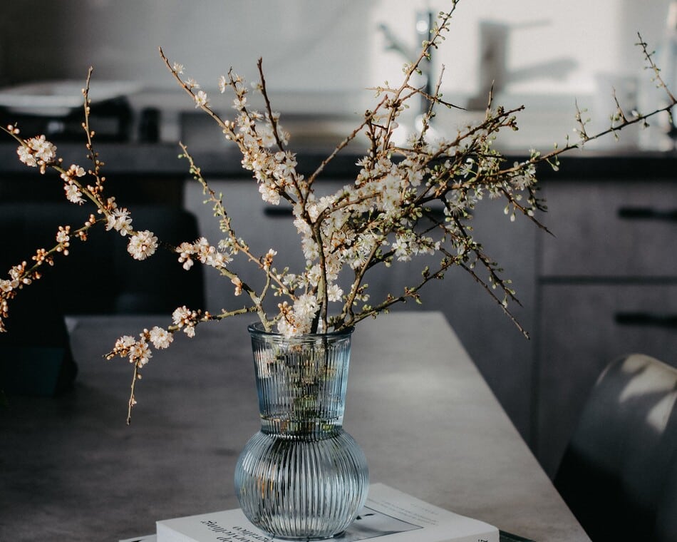 Jarrón de vidrio con flores decorativas en la cocina